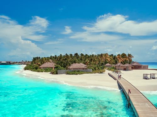 Free Stunning view of a tropical island with clear turquoise waters, white sand, and palm trees. Stock Photo