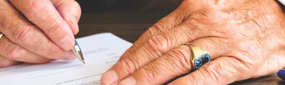Pessoa assinando documentos em Portugal — processo de regularização