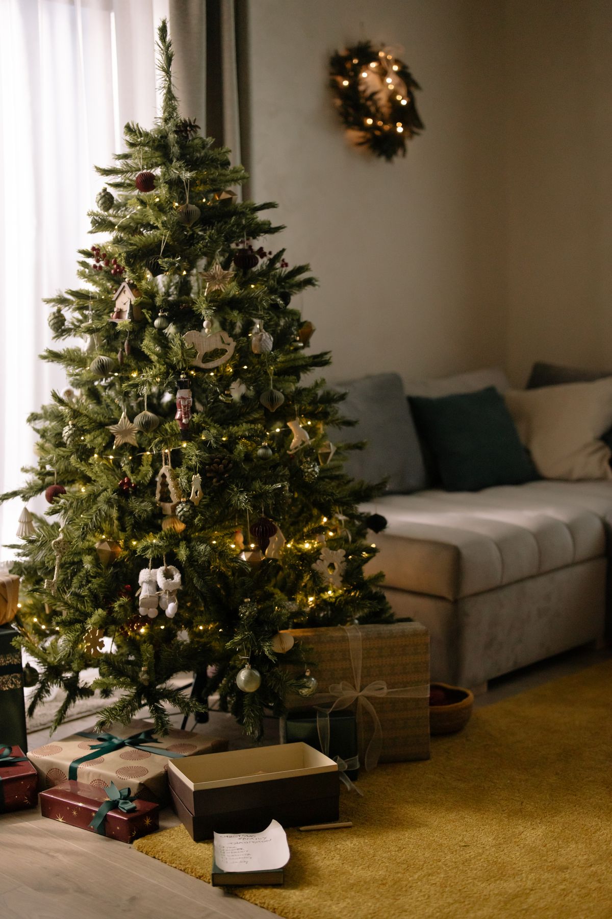 Árvore de Natal com luzes bem distribuídas Árvore de Natal decorada com luzes acesas em sala aconchegante