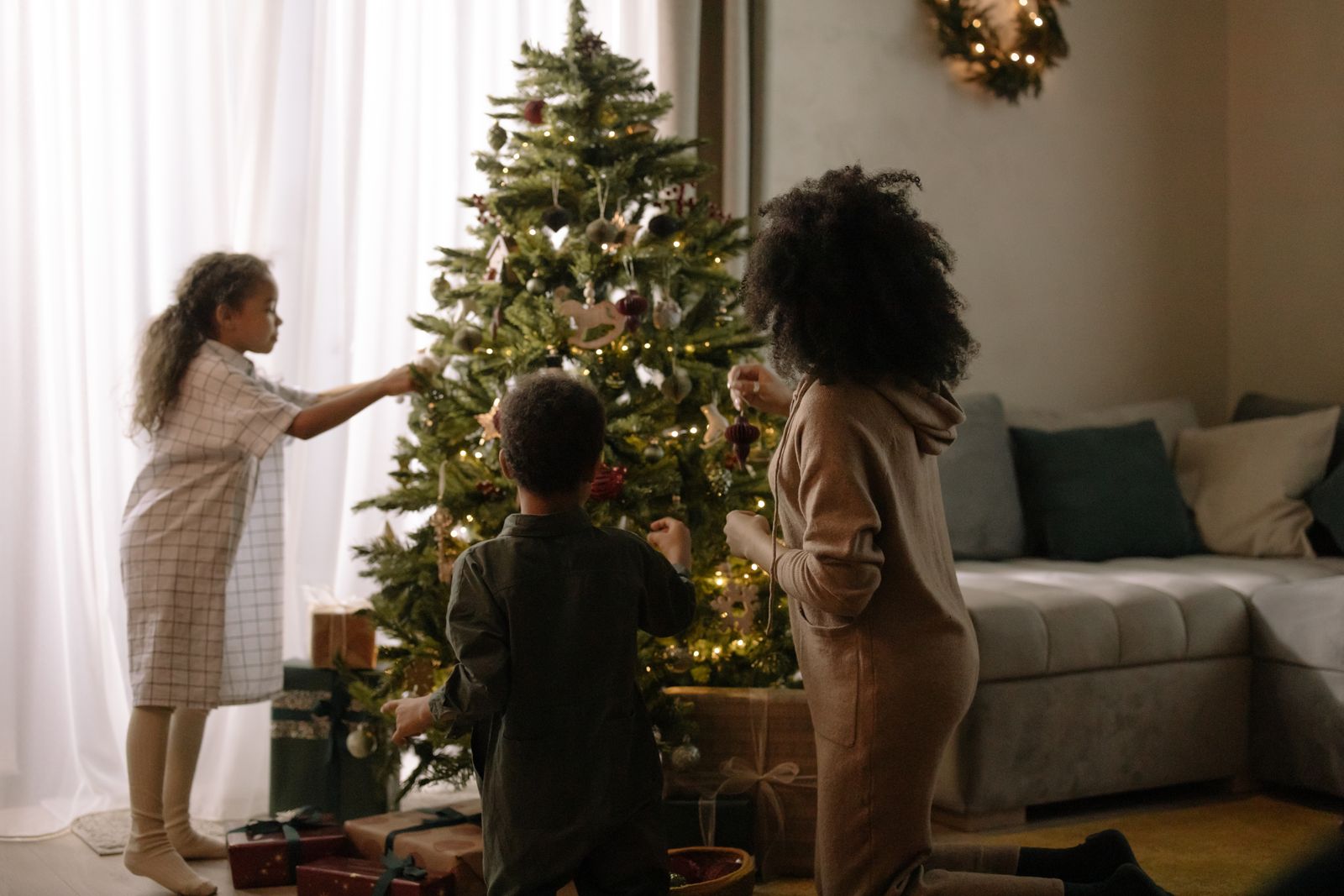 A family decorating the Christmas tree together at home