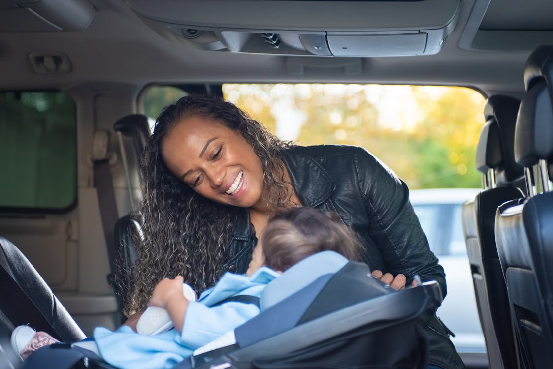 Woman in Black Leather Jacket Sitting on Car Seat