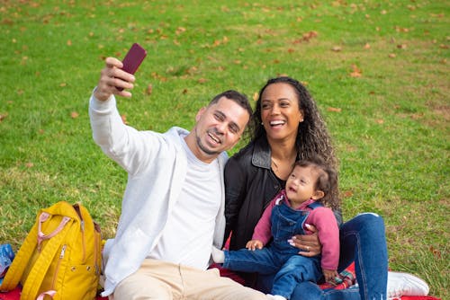 
A Father Taking a Selfie with His Family on a Park