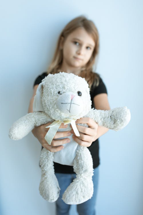 Free A Girl in a Black Shirt Holding a Stuffed Toy Stock Photo
