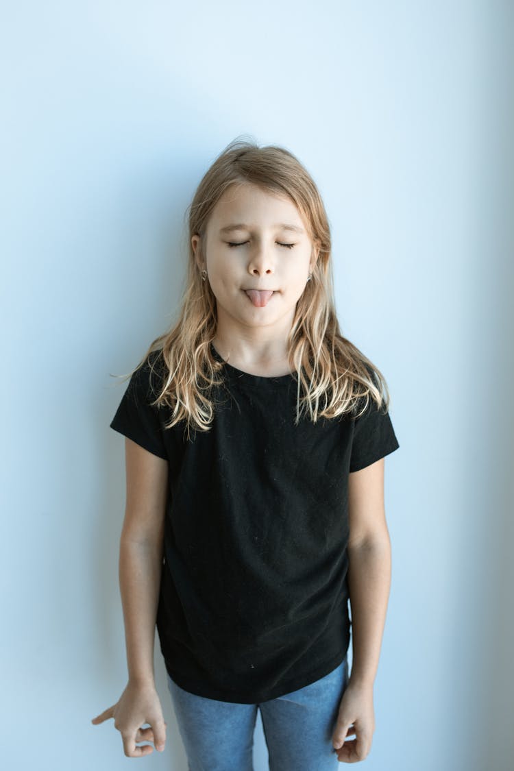 
A Girl Wearing A Black Shirt With Her Tongue Out