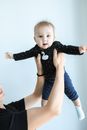 Woman in Blue Long Sleeve Shirt Carrying Baby in Black and White Polka Dot Onesie
