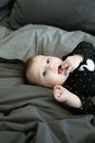 Baby in Black and White Polka Dot Onesie Lying on Grey Textile