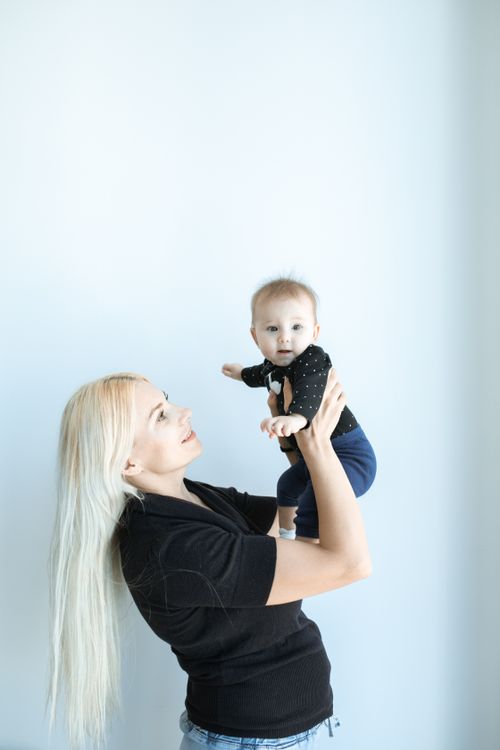 Free A happy mother holds her cute baby in a peaceful, bright setting. Perfect for motherhood themes. Stock Photo