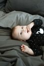 A Cute Baby Girl in Black Polka Dots Shirt Lying on the Bed while Sucking Her Fingers