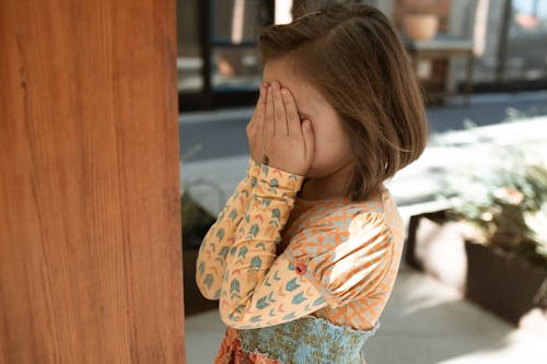 Vrouw In Wit Rood En Groen Bloemen Shirt Met Lange Mouwen Voor Haar Gezicht