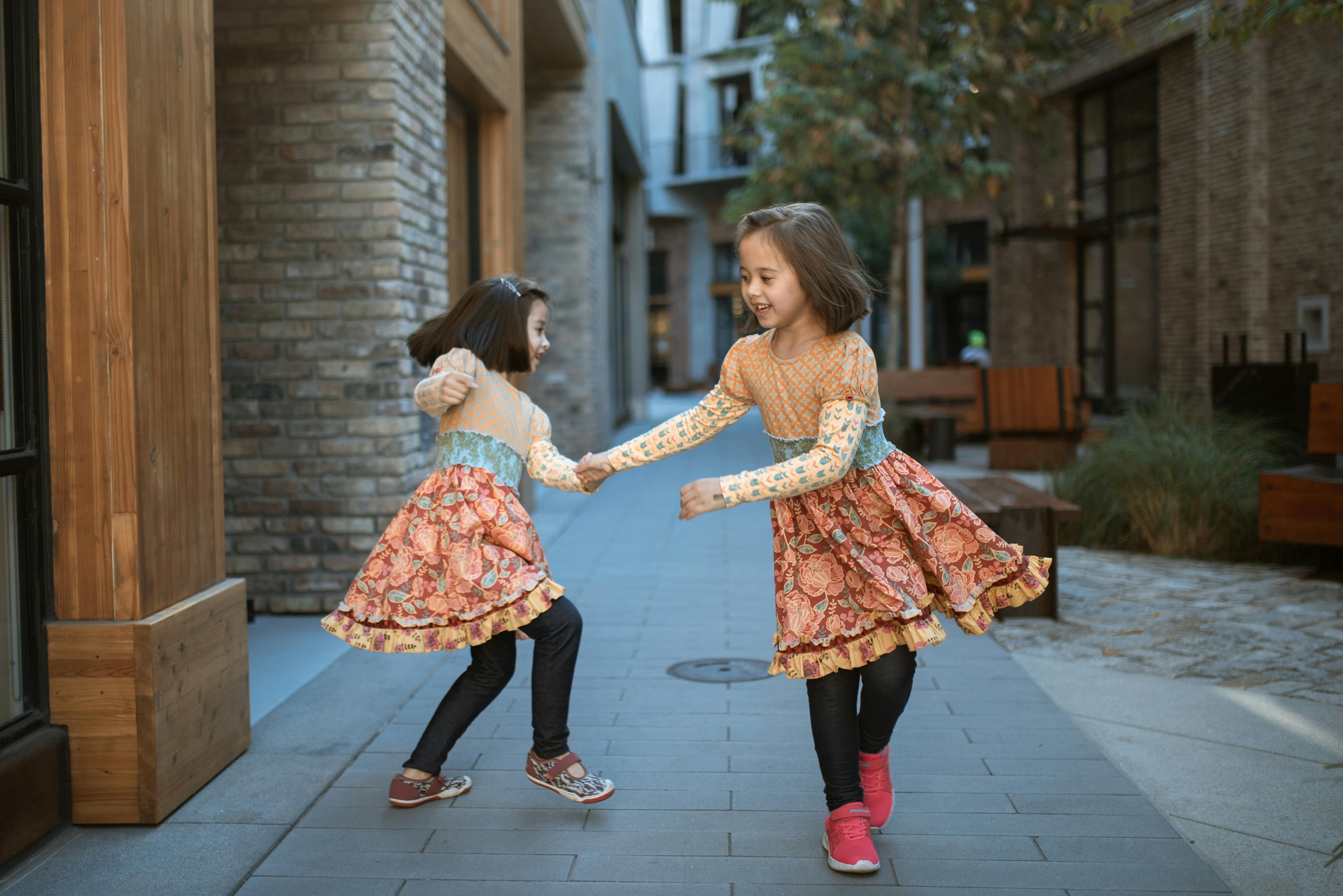 two girls playing on sidewalk