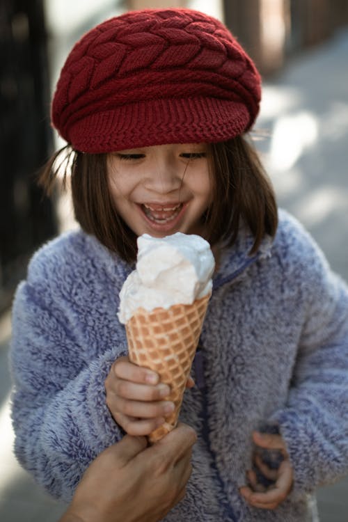Little Girl in Blue Coat Holding Ice Cream Cone