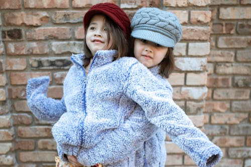 Free Girl in Gray Knit Cap Embracing Her Sister Stock Photo