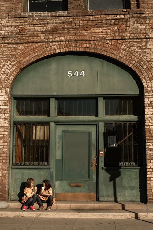 Two Little Girls Sitting Near Door