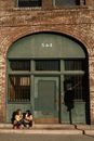2 Women Sitting on Chair Near Door
