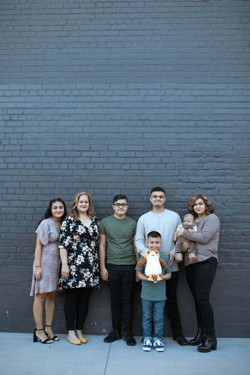 Group of People Standing Beside Brick Wall