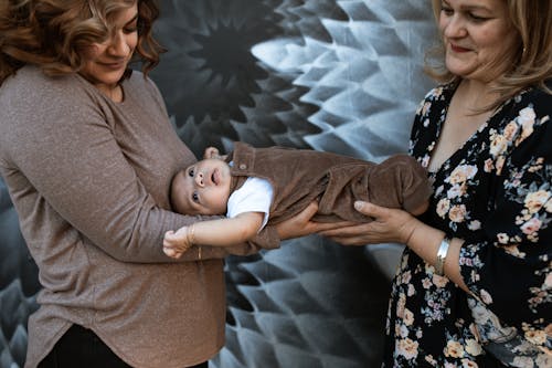 Vrouw In Bruine Trui Met Baby In Zwart Witte Bloemenjurk