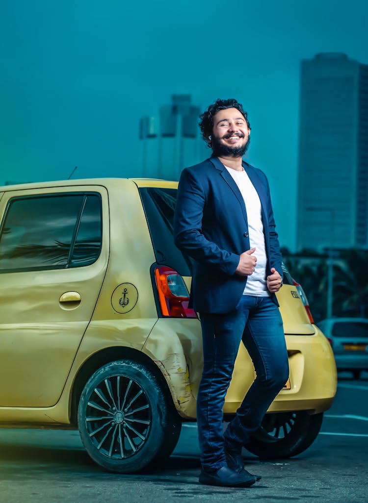 A Man Standing Beside A Car 