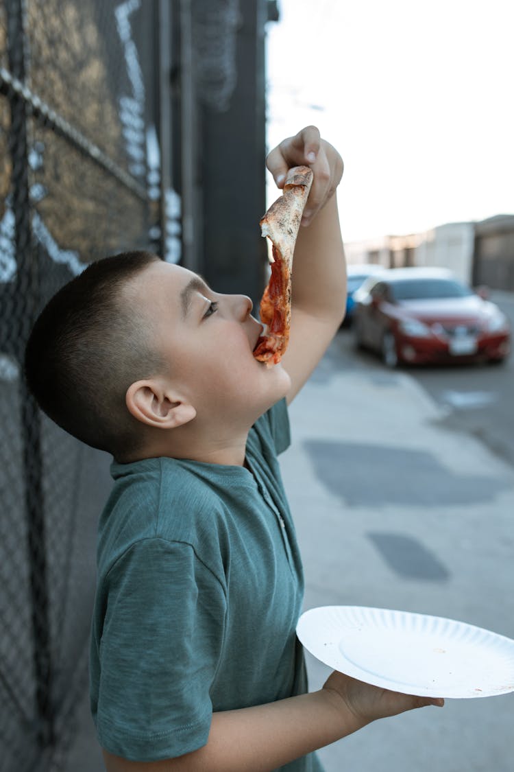 Boy In Blue Crew Neck T-shirt Eating Pizza