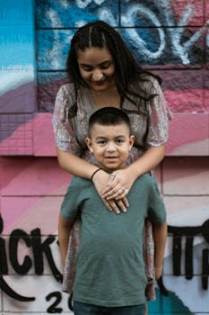 A happy mother and son pose in front of a vibrant graffiti wall, showcasing family togetherness and love.