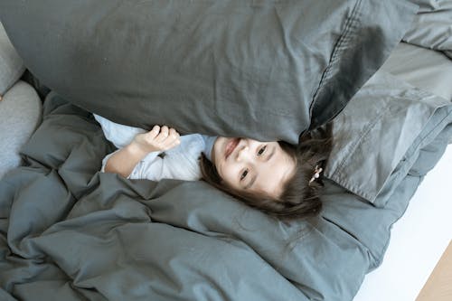 Menina De Camisa Branca Deitada Na Cama