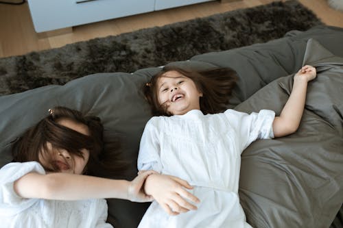 Two Children Playing in Bed