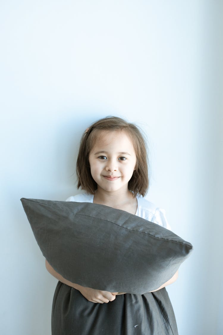 Girl In White Shirt Holding Gray Pillow