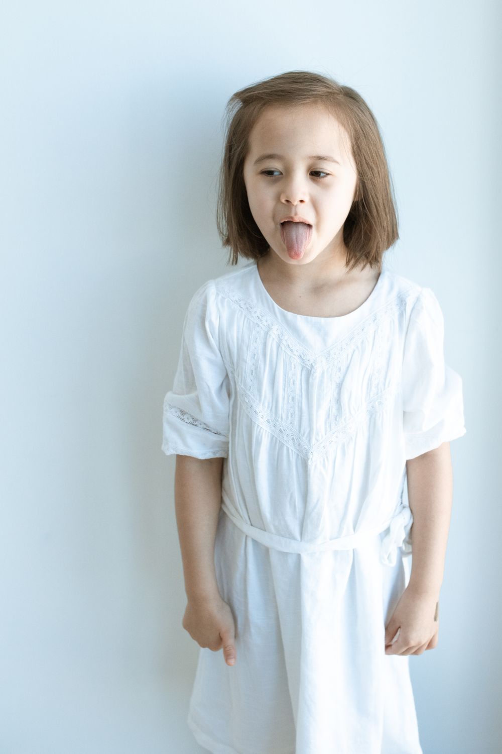 Girl in White Dress Standing Near a White Wall · Free Stock Photo