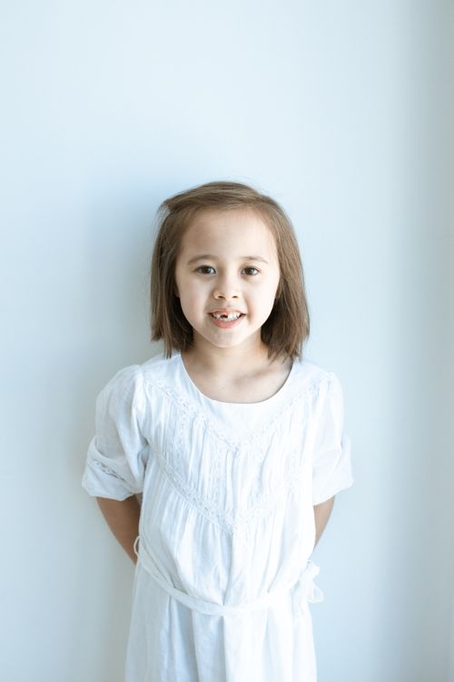 A Cute Girl Wearing a White Dress Smiling · Free Stock Photo