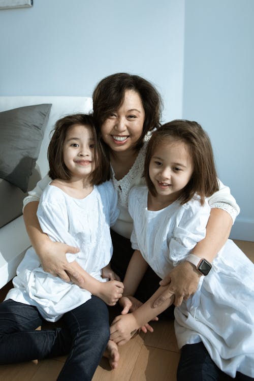 Free Parent Witting on the Floor with Her Kids Stock Photo