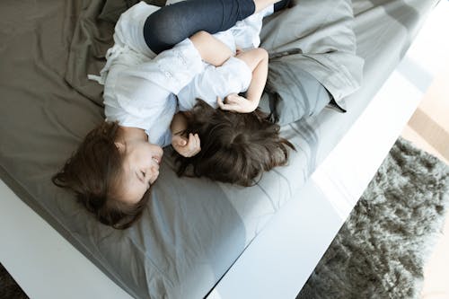 Two Girls Playing Together on a Bed