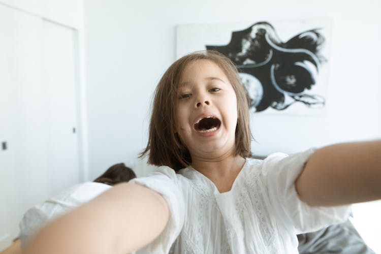 Girl In White Top Smiling With Mouth Open