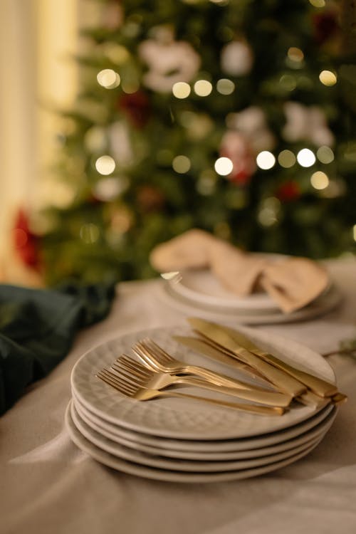 Free Knives and Forks on a Pile of Ceramic Plates on the Table Stock Photo