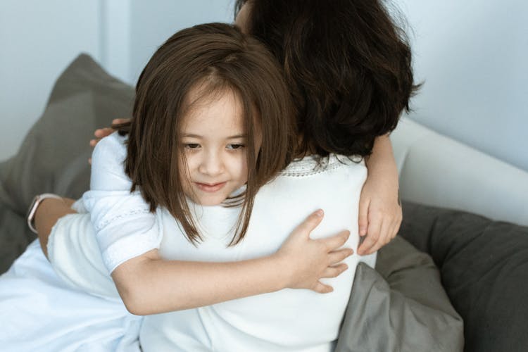 A Young Girl Hugging Her Mother