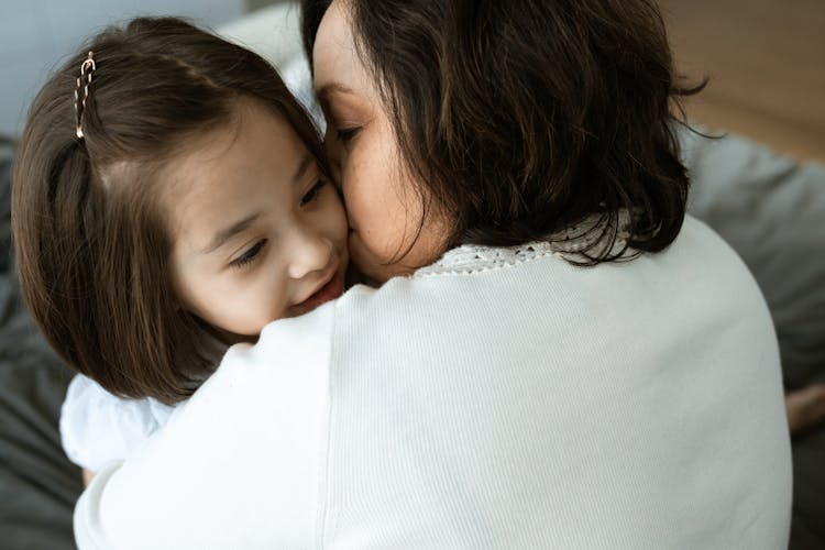 Woman Kissing A Girl On Cheek