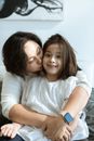 Woman in White Long Sleeve Shirt Hugging Girl in White Shirt