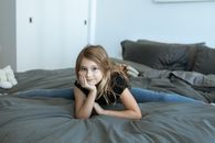 Girl in Black Tank Top Lying on Bed