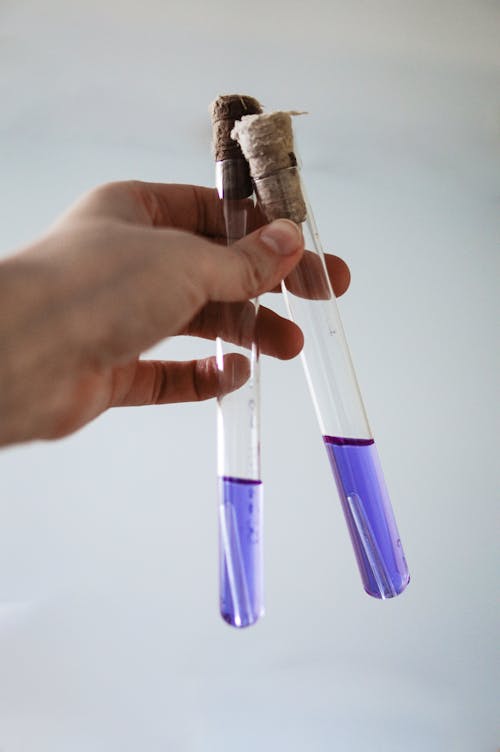 Person Holding Tes Tubes with Blue Liquid