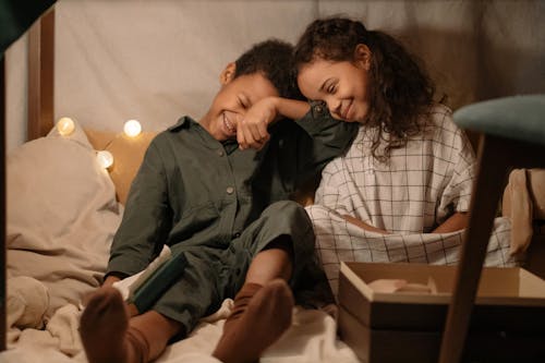 Siblings Sitting on the Bed