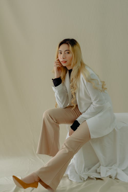 Woman in White Blazer Posing with Hand on Cheek