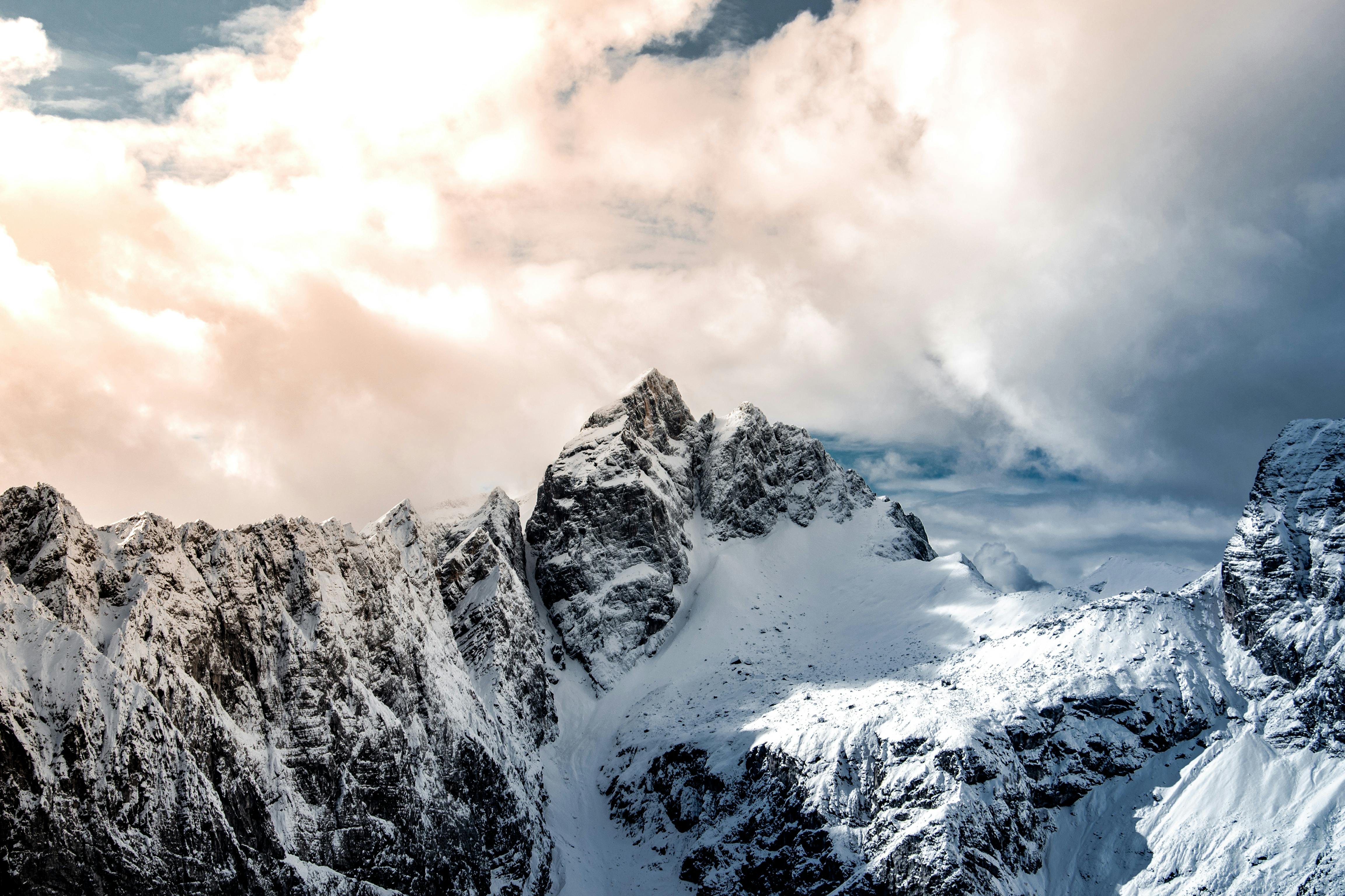 Prescription Goggle Inserts - Breathtaking view of snowy peaks in Slovenia under dramatic clouds, capturing winter's serene beauty.