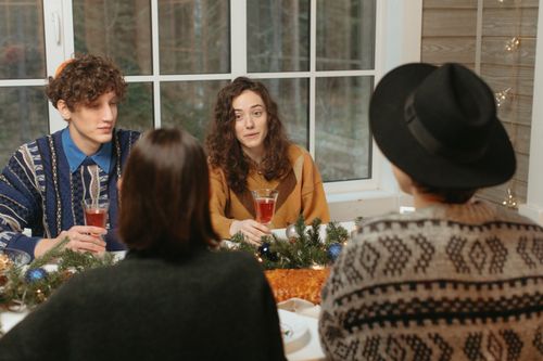 Free A group of friends enjoying a festive holiday meal with drinks and decorations. Stock Photo