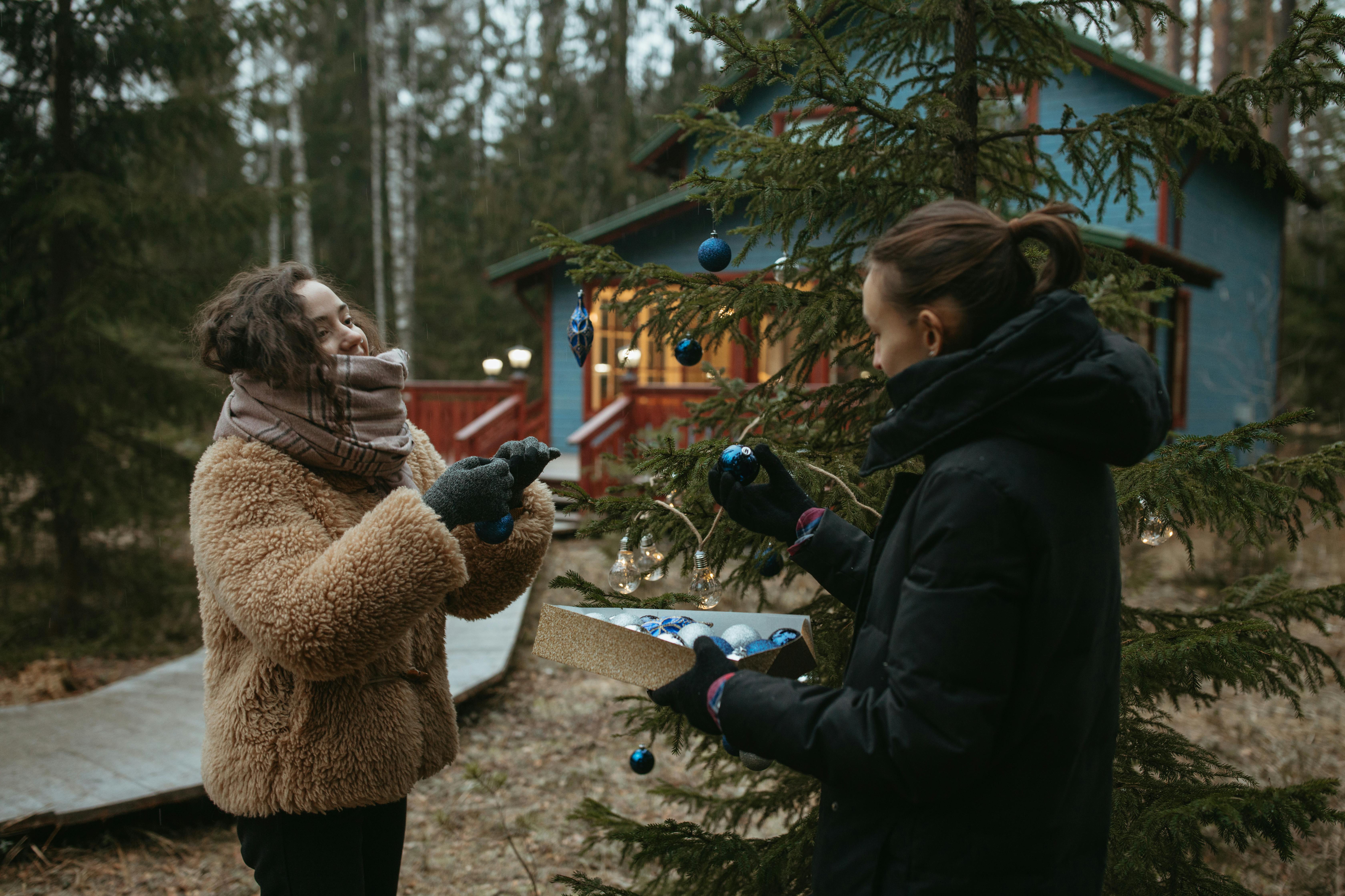 woman in brown fur coat standing near green tree