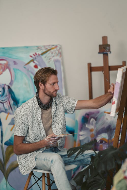 Man in Button Down Shirt Painting on a Canvas