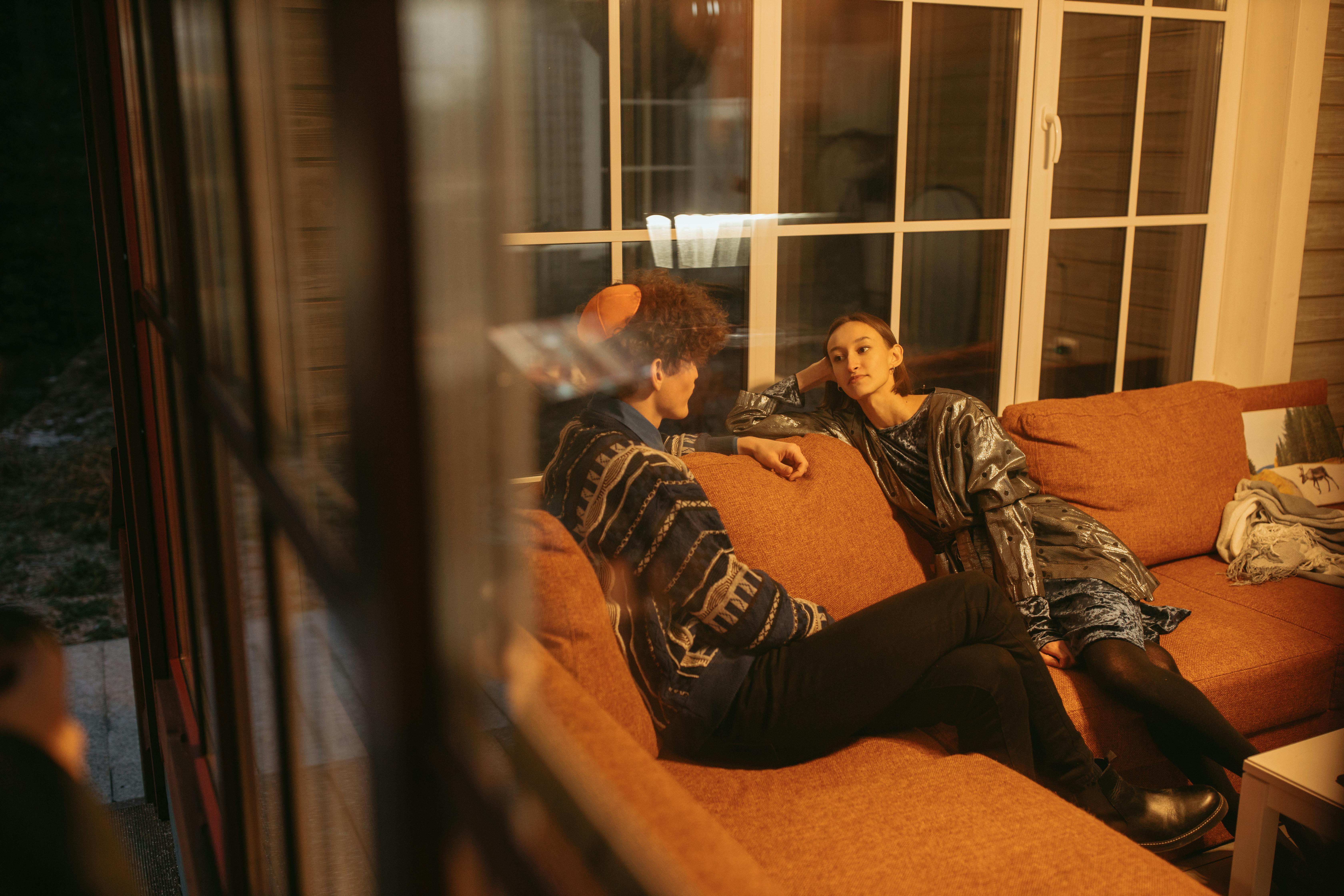 A coaching-style conversation between two people on a couch, the more direct working pace of spiritual coaching compared to spiritual direction.