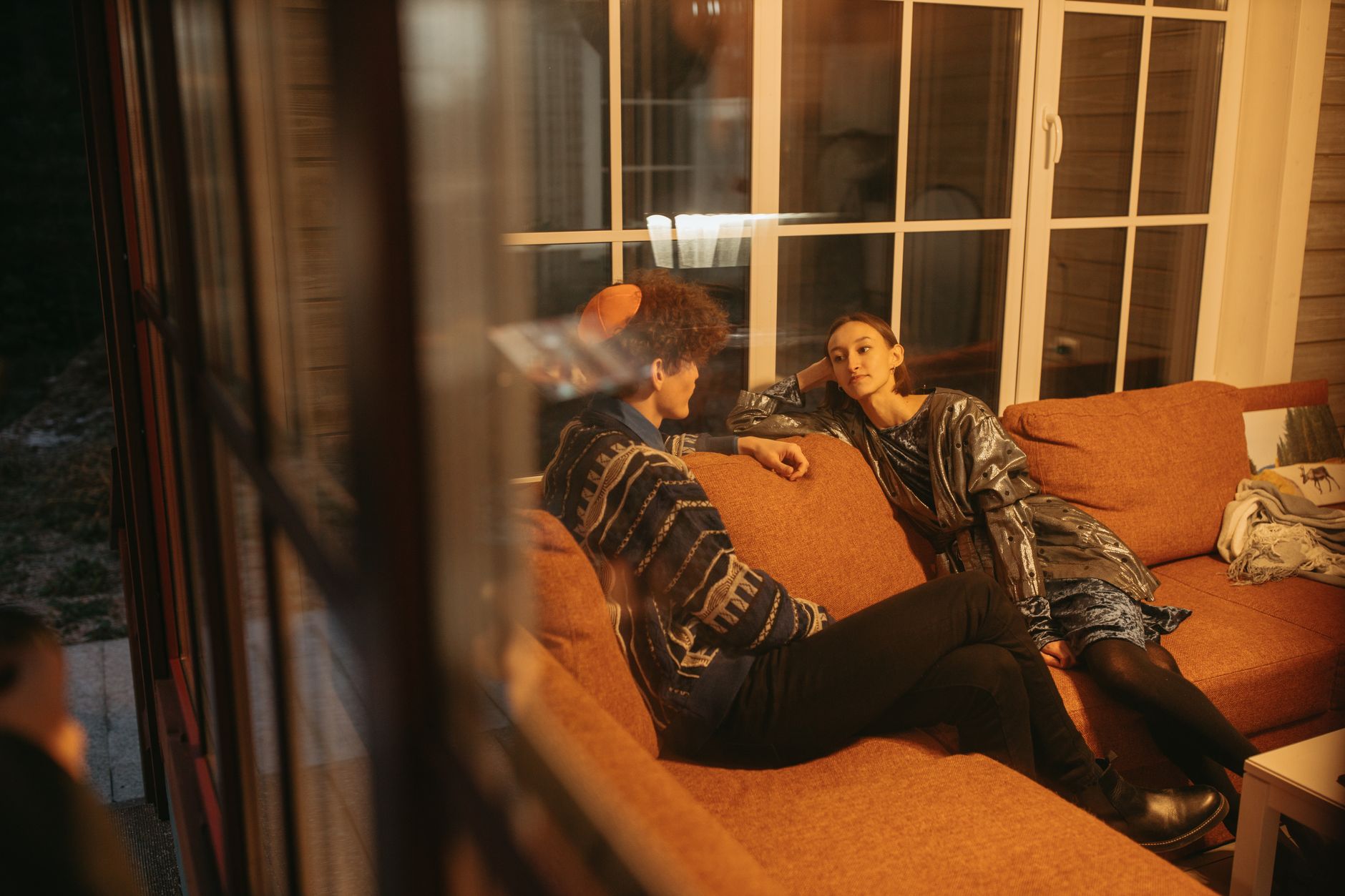 Two colleagues in an unhurried conversation on a lounge sofa in late afternoon light — photo by Yaroslav Shuraev on Pexels