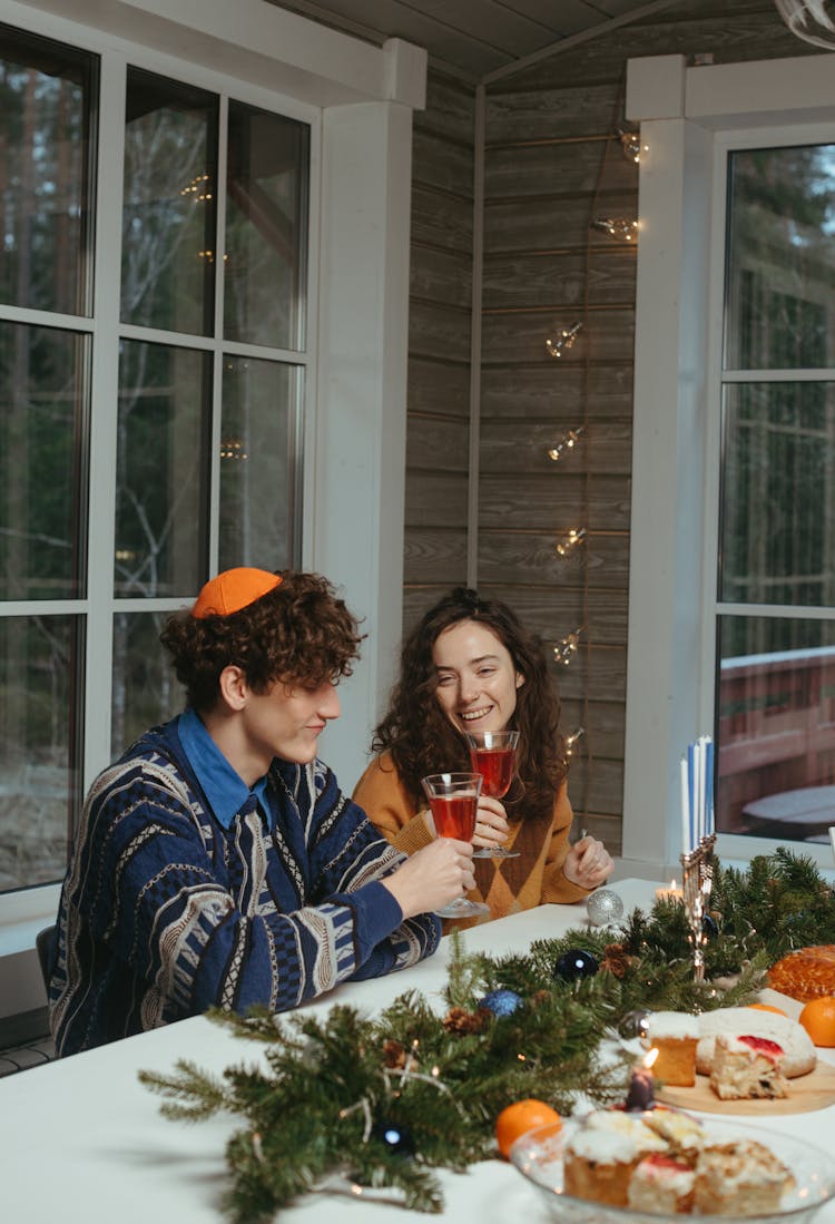 A Man And A Woman Toasting Their Wine Glasses