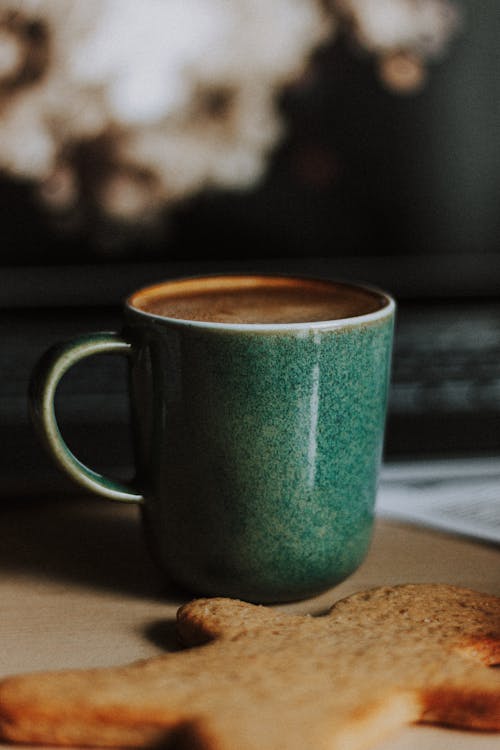 Free Mug of delicious cappuccino and cookie on table Stock Photo