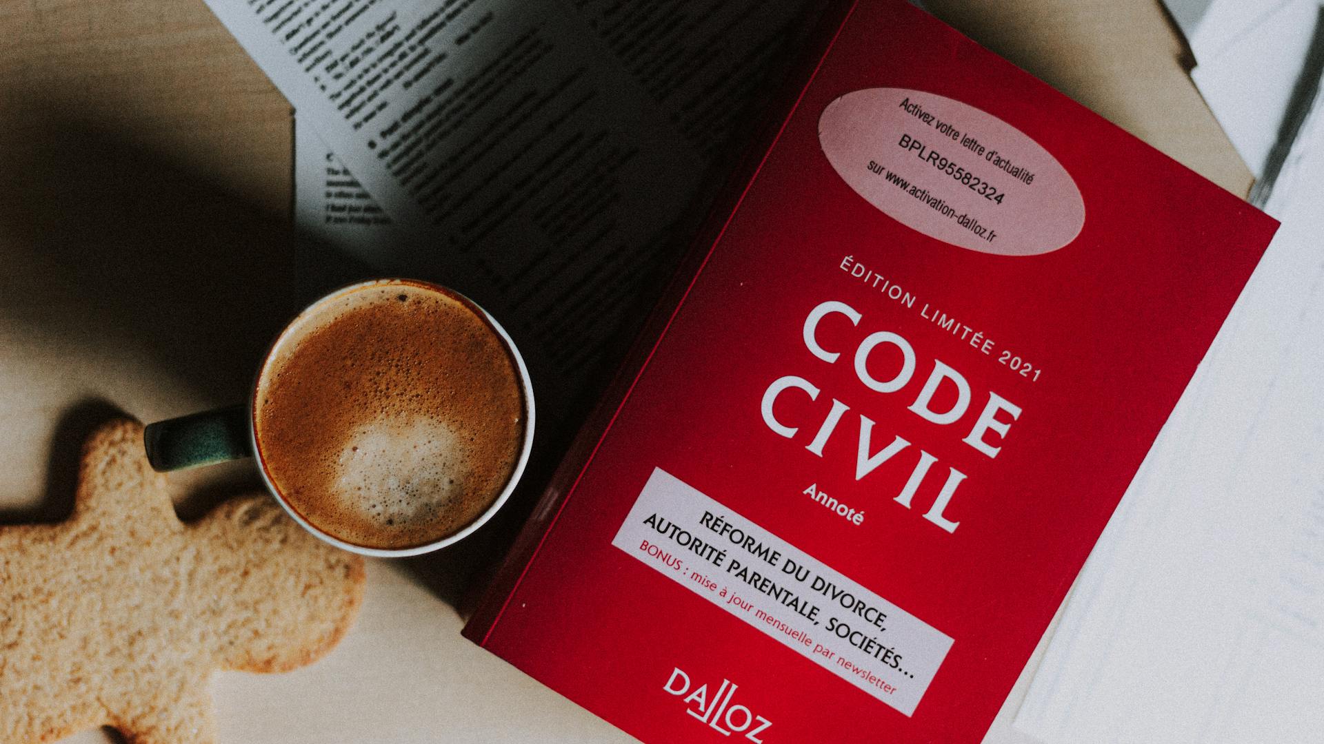 Cup of coffee and Code Civil book on a desk, perfect for study scenes.