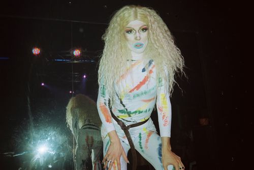 Free A drag queen in colorful costume posing with reflection on stage. Stock Photo