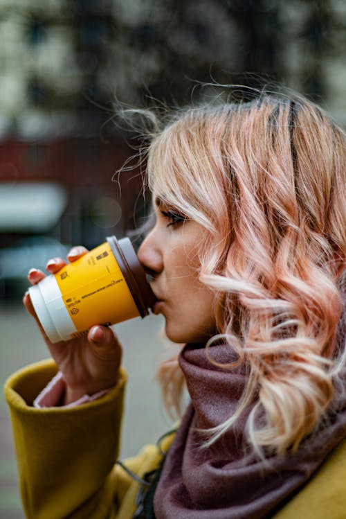 Woman Drinking from Disposable Paper Cup with Lid 